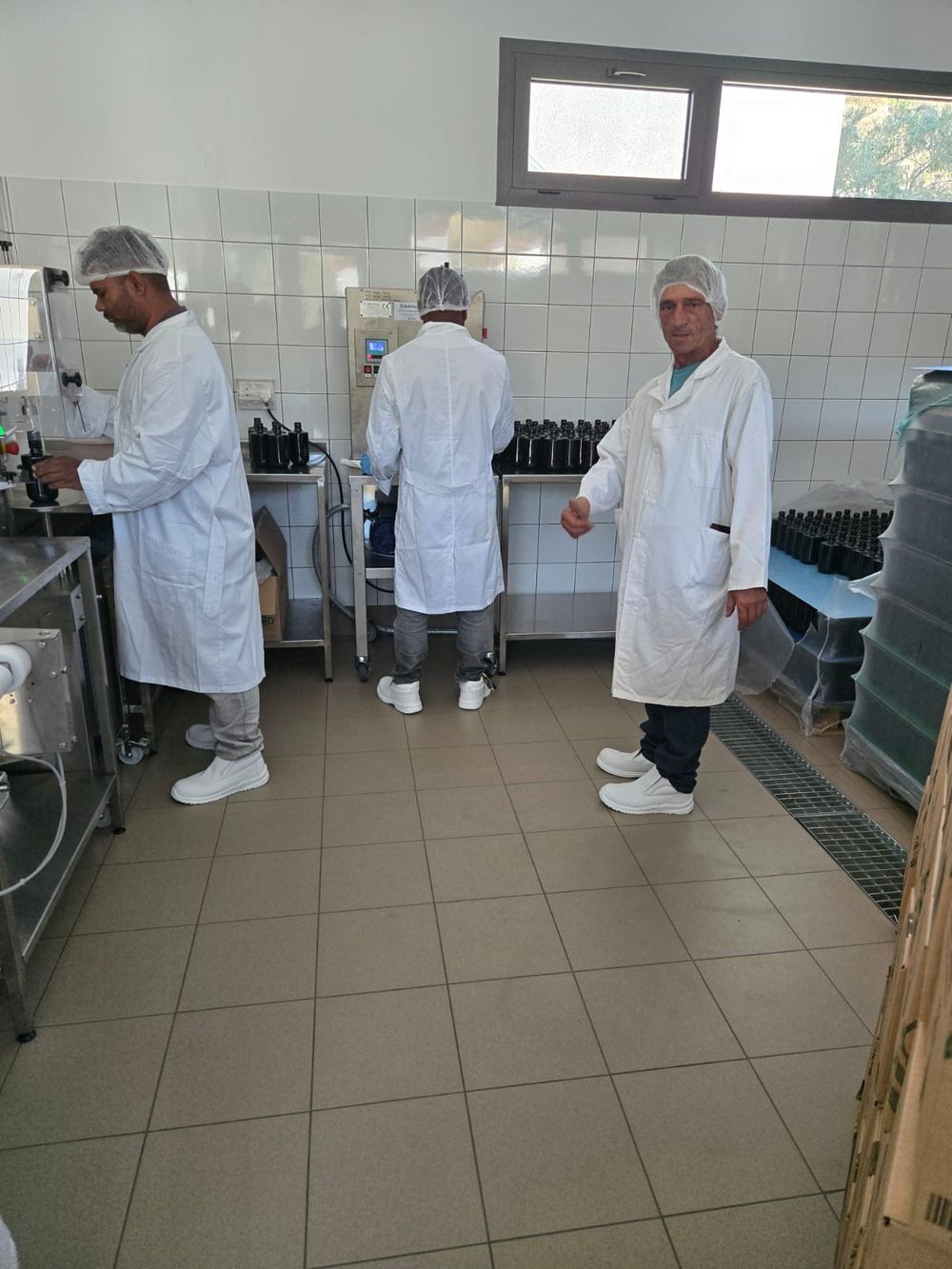 Sofroni at the bottling line as the oil is filled into dark glass bottles